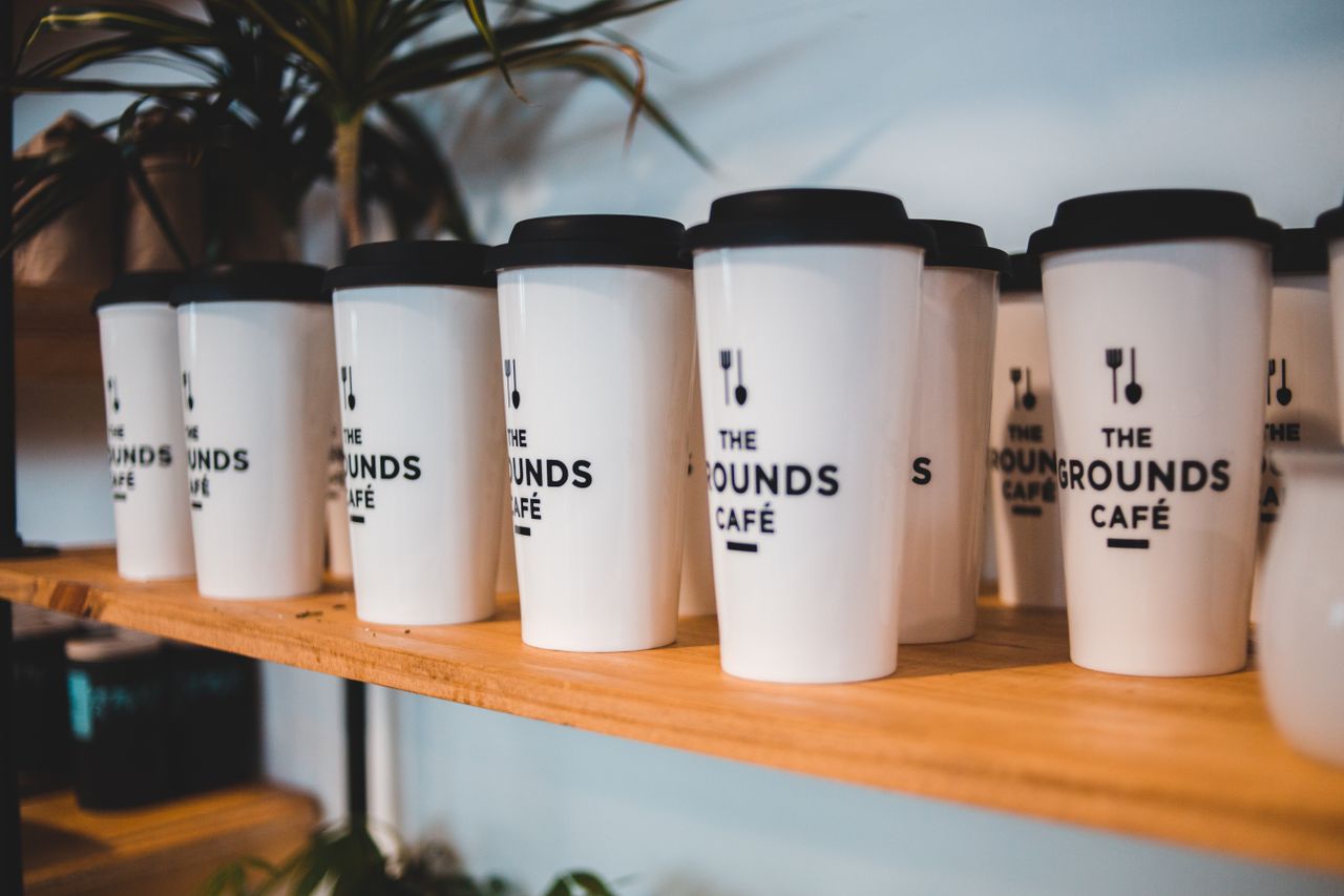 why-choose-us Designed white for coffee with black silicone lids and cutlery symbols on shelf for sale in coffee shop